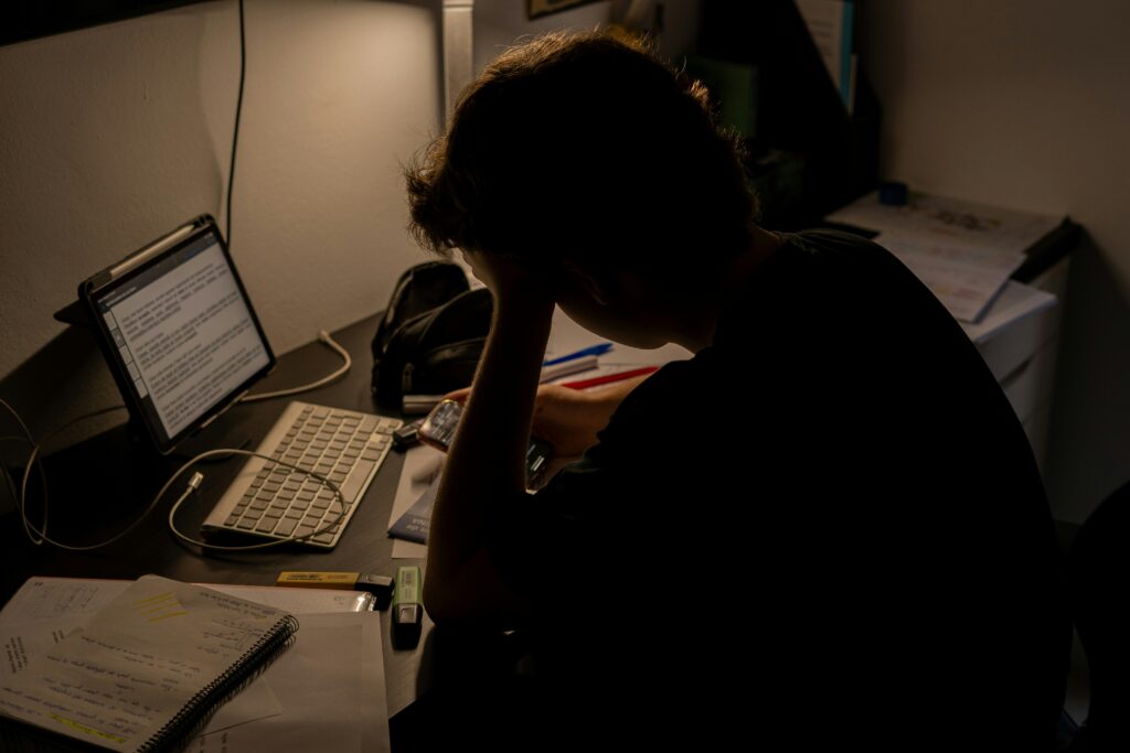 Work Anxiety: When Stress About Your Job Is Something More Adult at a desk with a quietly worried expression, representing the experience of work anxiety beyond ordinary job stress.