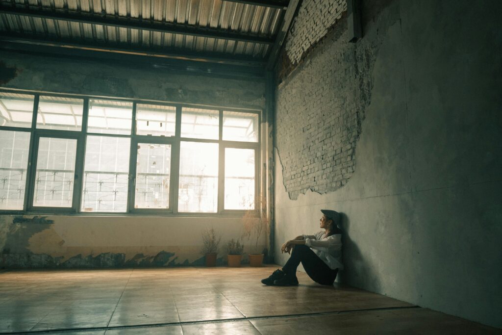 person sitting in an empty room, lonely.