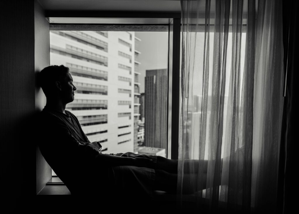 Man sitting alone with a quiet, inward expression