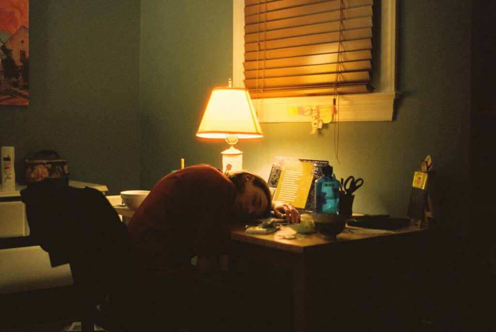 ADHD Burnout: Why Neurodivergent People Hit the Wall Harder Adult resting with head down in exhaustion