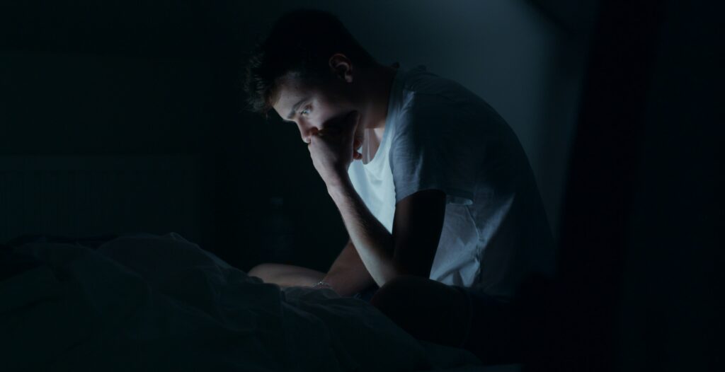man anxiously looking at his phone screen